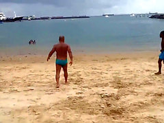 Mestre maludo de sunga treinando na praia