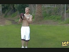 Strong tattooed blonde gay hunk strips outdoors